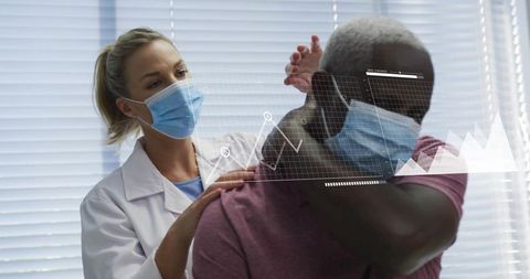 Clinician examining patient raising arm for shoulder assessment with digital hud graphics