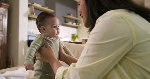 Mother Holding Baby Daughter in Cozy Living Room Setting