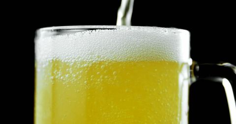 close-up beer pour with foam and bubbles against black background - Download Free Stock Images Pikwizard.com