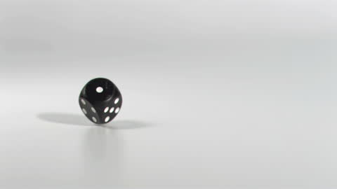 Black Dice Bouncing in Slow Motion on Grey Background