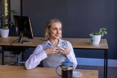 Professional Woman Enjoying Coffee at Minimalist Workspace with French Press