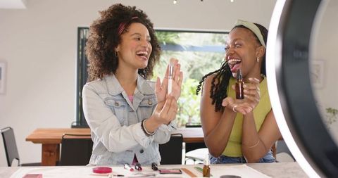 Young black and mixed-race beauty creators demonstrating skincare and makeup tutorial