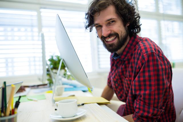 Male graphic designer smiling while working in office