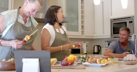 Senior Friends Enjoying Cooking Together in Modern Kitchen