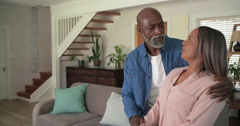 Senior couple sharing tender embrace in cozy modern living room, lifestyle concept