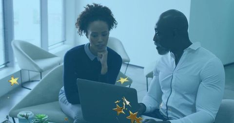Colleagues Discussing Reports with Laptop in Modern Office Lounge