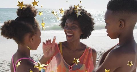 Sunlit family beach moment smiling mother laughing with children amid playful gold stars