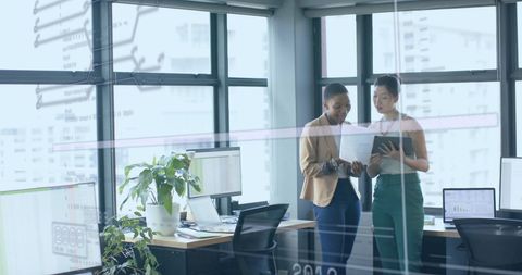 Financial data over diverse professionals collaborating in modern office