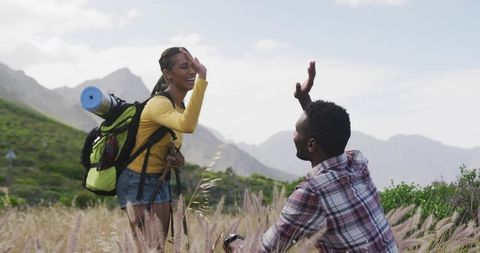 Joyful Hiking Couple Sharing High Five in Green Mountain Meadow