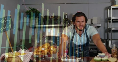 Artisan baker leaning at counter displaying croissants and cupcakes under glass dome