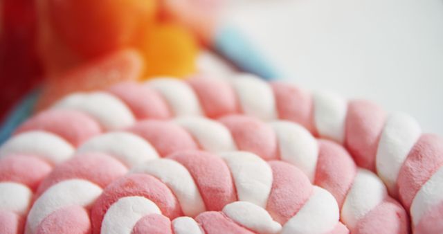 A close-up of pink and white marshmallows arranged in a pattern, with copy space. Marshmallows like these are often used in desserts and as a sweet treat in various culinary creations.