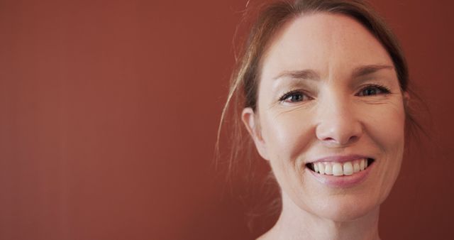 Smiling caucasian woman face close up with copy space. Indoors, feminity, wellbeing and writing concept, unaltered.