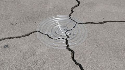 Water ripple on cracked concrete ground