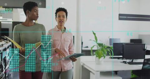 Two Businesswomen Walking Through Modern Open Office Consulting Tablet and Data Charts