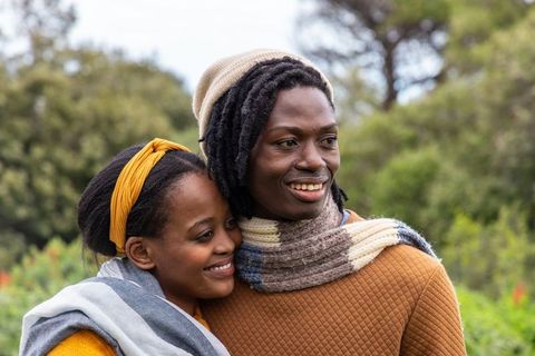 African American Couple Embracing Outdoors, Smiling in Cozy Autumn Knitwear and Scarves