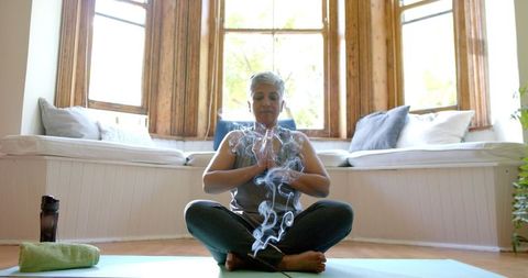 Senior Woman Meditating with Incense in Tranquil Home Setting