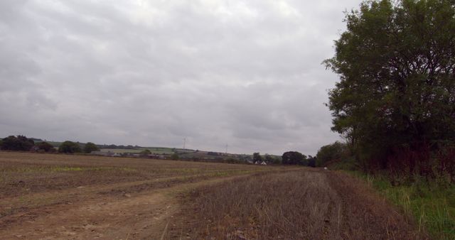 Overcast Countryside with Bare Fields and Distant Wind Turbines - Download Free Stock Images Pikwizard.com