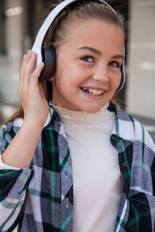 Smiling Girl Adjusting Headphones Outdoors Urban Lifestyle