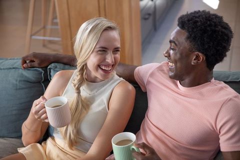 Diverse couple enjoying coffee together in modern lounge