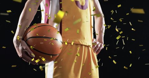 Confetti Shower on Female Basketball Player Holding Ball Celebrates Victory