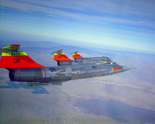 This historic image captures three NASA F-104N jet aircraft flying in formation over a desert landscape on October 24, 1963. The visible aircraft numbers are 011, 012, and 013. Such images are ideal for use in aviation history articles, aerospace education materials, and vintage aviation collections. Aviation enthusiasts will appreciate the detailed view of these early supersonic research aircraft and their formation flying.