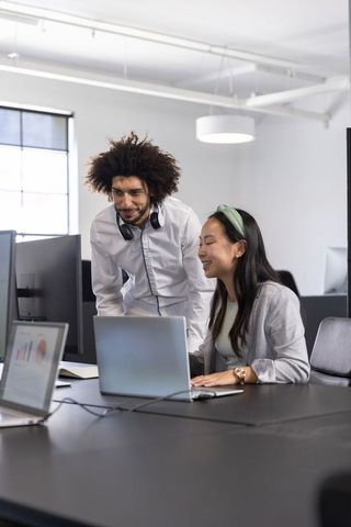 Diverse coworkers collaborating in open plan office
