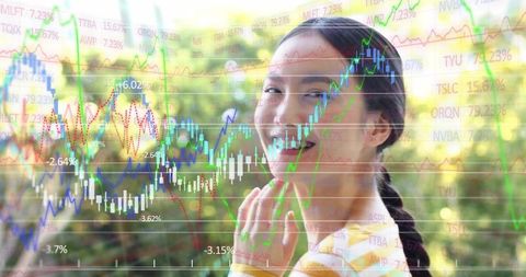 Smiling asian woman touching chin in double exposure with rising stock charts, park background