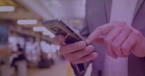 Senior Professional Engaging with Smartphone in Open-Plan Office