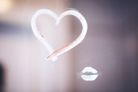 Red Lip Impression Beside Drawn Heart on Foggy Glass