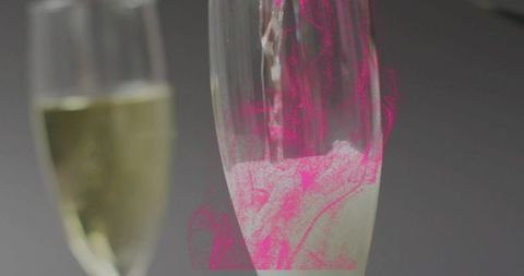 Pouring champagne flute with magenta glow, delicate bubbles, soft reflections and bokeh