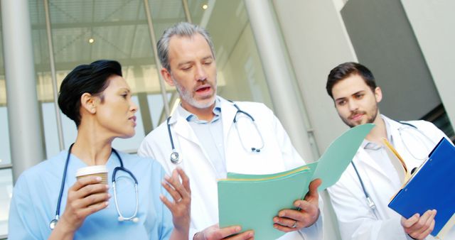 Medical Team Discussing Patient Charts Outside Hospital - Download Free Stock Images Pikwizard.com