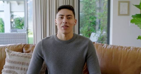 Young Man in Grey Sweater Relaxing on Comfortable Couch