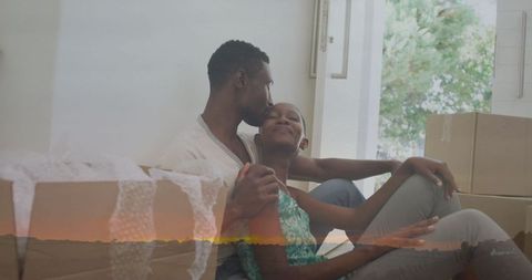 Loving Couple Embracing on Floor Surrounded by Moving Boxes