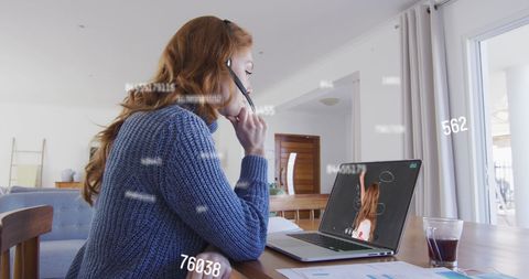 Woman Analyzing Data on Laptop in Home Office