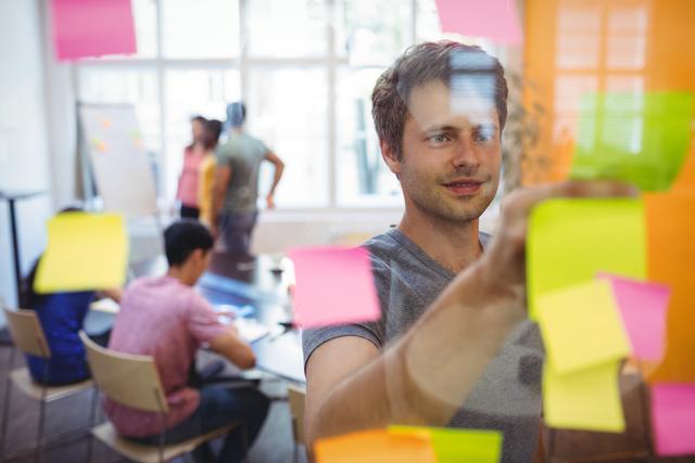 Business executive reading sticky notes in office
