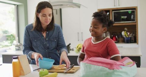 Mother and Daughter Preparing School Lunch Together