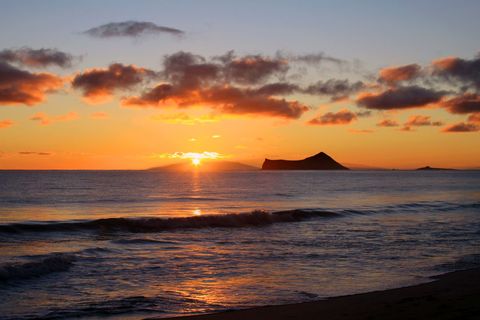Stunning Island Sunset Over Calm Ocean Waves
