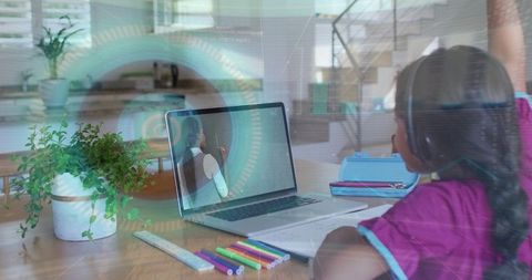 Young student raising hand while studying at home with laptop and headphones hud overlay