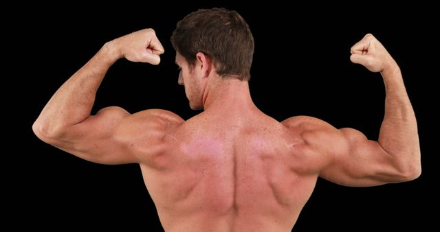 Rear view of caucasian strong man flexing muscles with copy space on black background. Boxing, strength, fitness concept.
