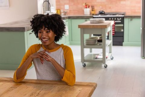Joyful african american woman relaxing in modern kitchen