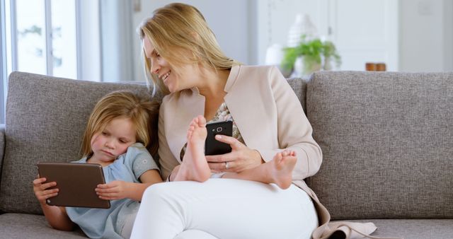 Mother and Daughter Relaxing on Couch Using Digital Devices - Download Free Stock Images Pikwizard.com