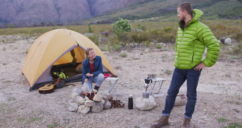 Couple Enjoying Mountain Camping with Campfire and Tent
