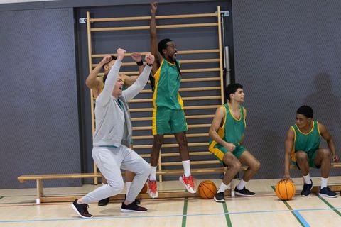 Diverse Male Basketball Team Celebrating Victory in Gym
