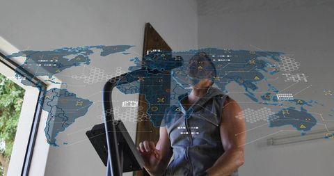 Man exercising on cardio console with holographic world map overlay in home gym