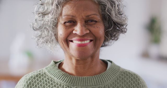 Portrait of happy senior african american woman looking at camera and smiling. Retirement and spending time at home concept.