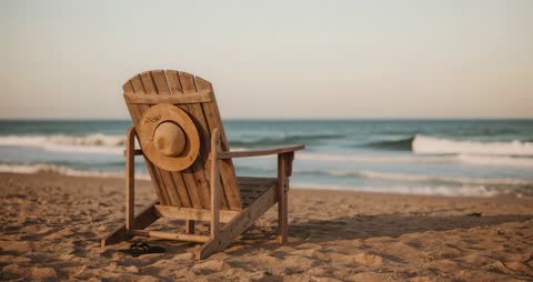 Serene Beach Scene with Chair, Hat, and Rolling Waves