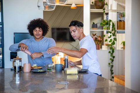 Diverse friends cooking duo preparing lunch in modern kitchen