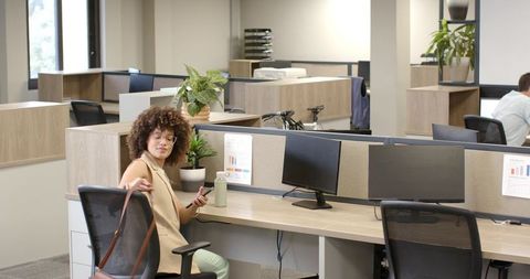 Confidence in Modern Office with Smartphone and Handbag Ready