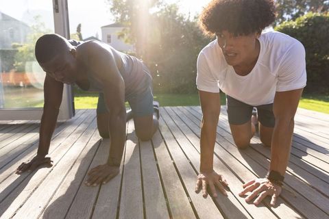 Diverse Friends Stretching on Wooden Deck in Sunlight