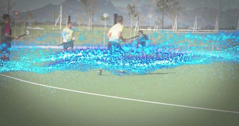 Field hockey players competing with electric blue motion trail on turf
